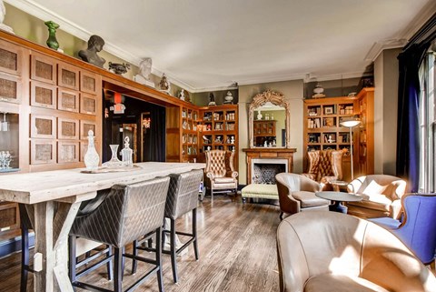 a living room filled with furniture and a bar and a fireplace